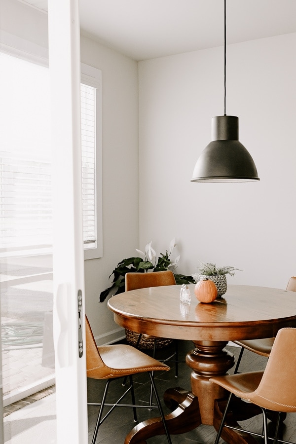 black pendant light fixture in a breakfast nook with leather chairs