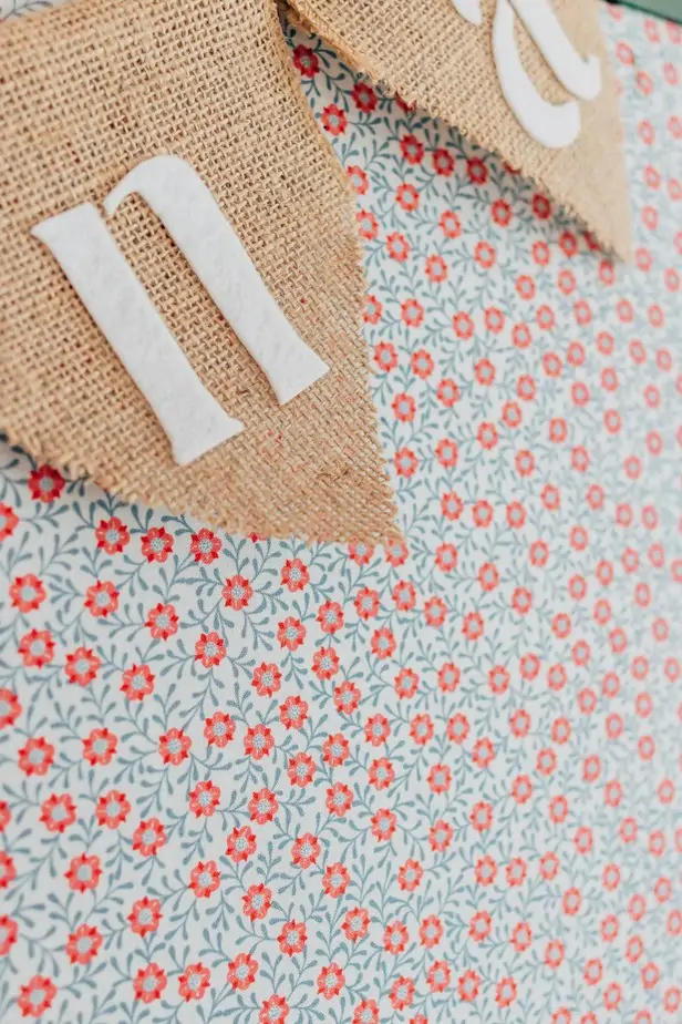 How to Make a Fabric Pinboard - Decor Hint A painted pin board with floral fabric fabric on a white desk - learn how to make a fabric pin board