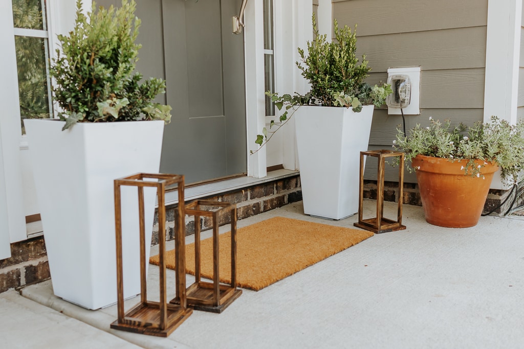 How to Paint Plastic Planters in 3 steps - Decor Hint white painted outdoor planters with greenery in them and wood lanterns