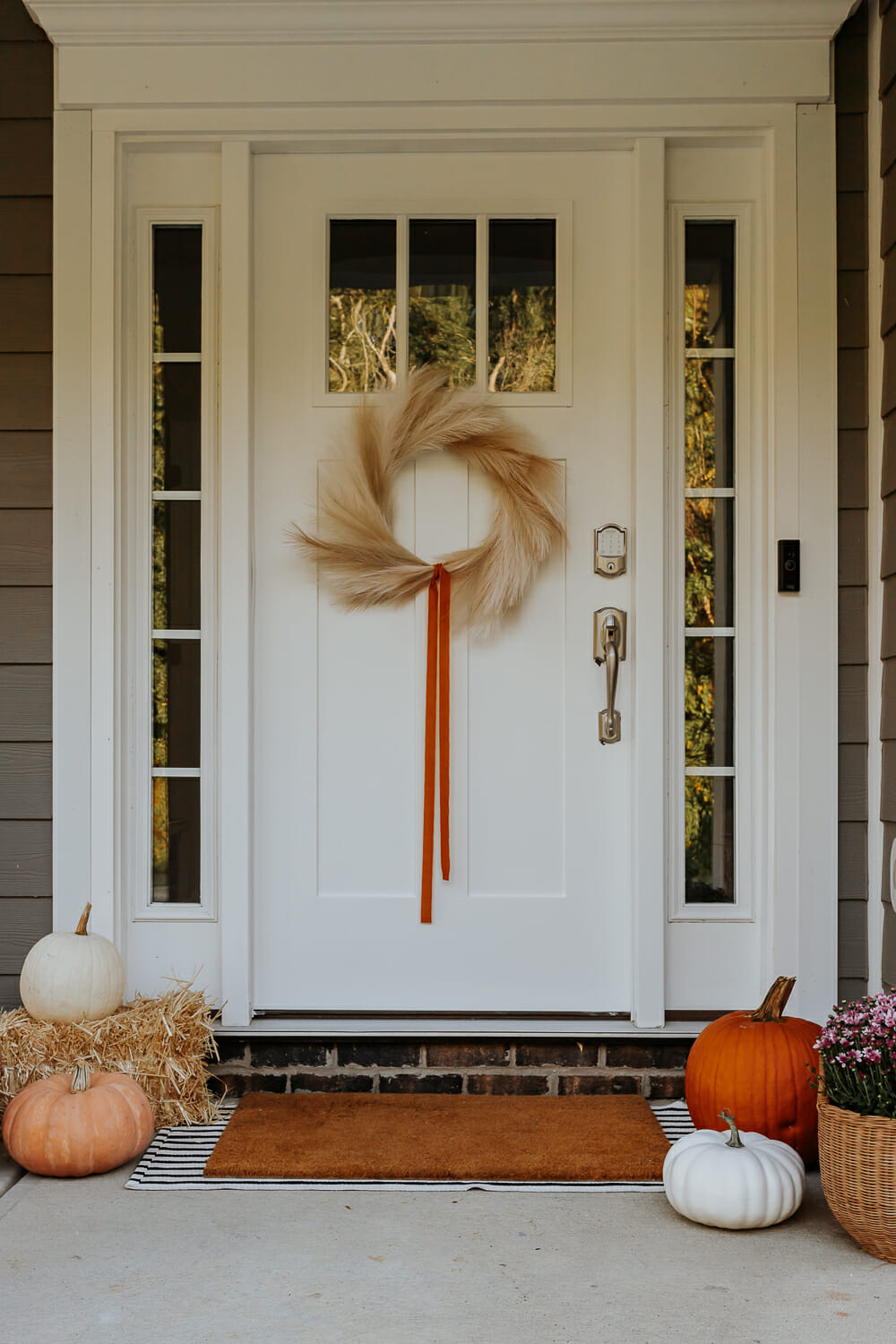 How to Paint a Front Door without Removing it - decorhint A white painted door with fall pumpkins and mums