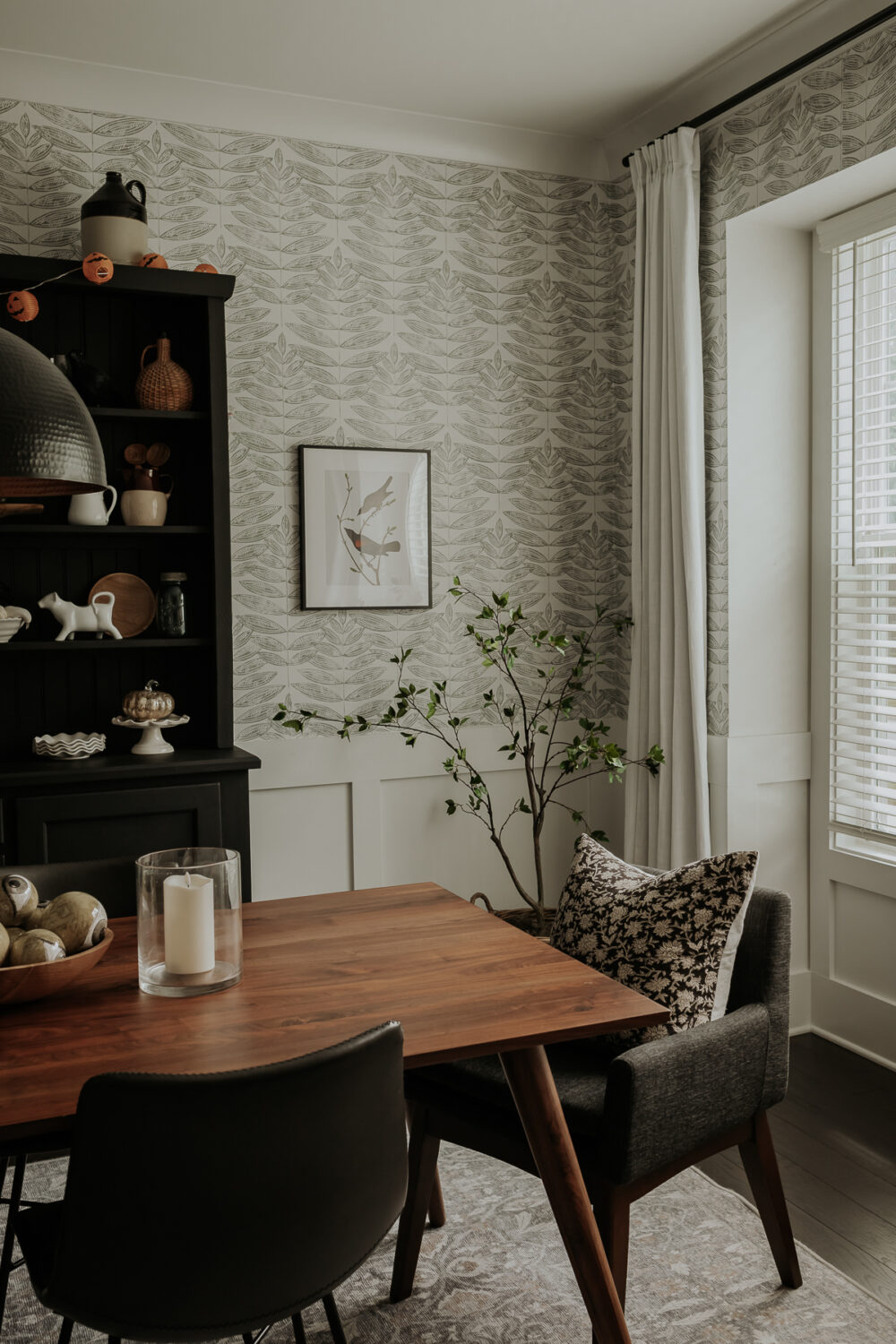 a faux tree in a basket in a dining room
