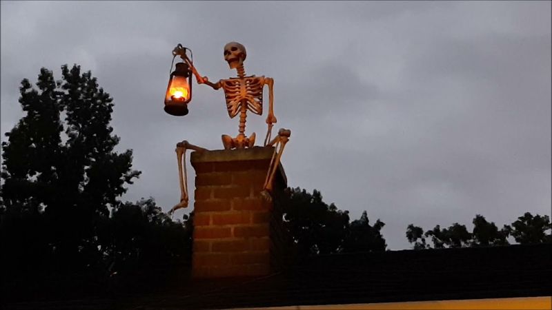 Skeletons Sitting On Rooftop Edges