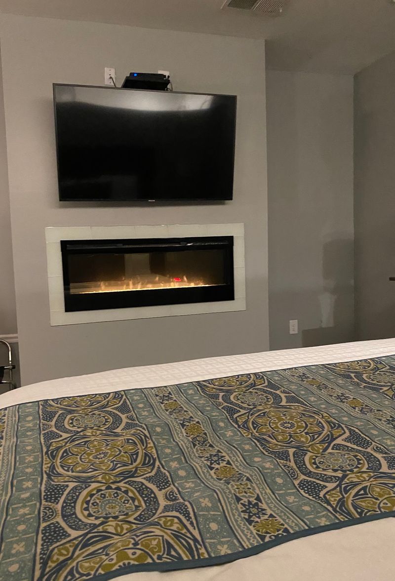 Fireplace Glowing At The Foot Of The Bed