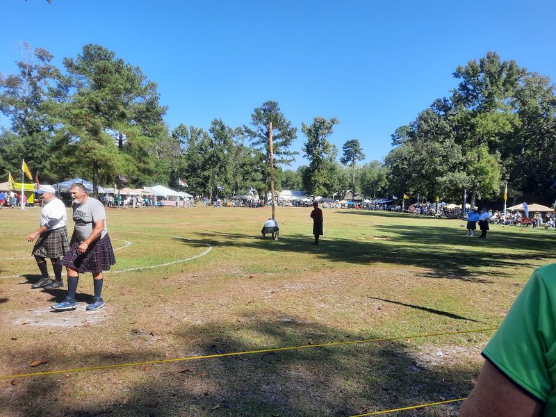 Athletes Launch A Weighted Sheaf Over A Rising Bar With A Pitchfork