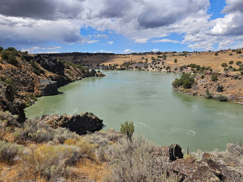 Visitors Hike Past Pioneer Tracks Pressed Into Rock At This Idaho Spot Near The Snake River - Decor Hint Cliffs, Boulders, And A Turquoise Stretch Of Snake River