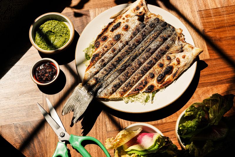 A Whole Grilled Fish Comes With Scissors And Lettuce Wraps